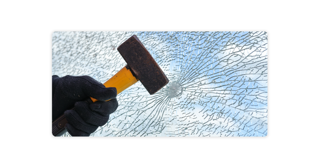 person using hammer to break glass